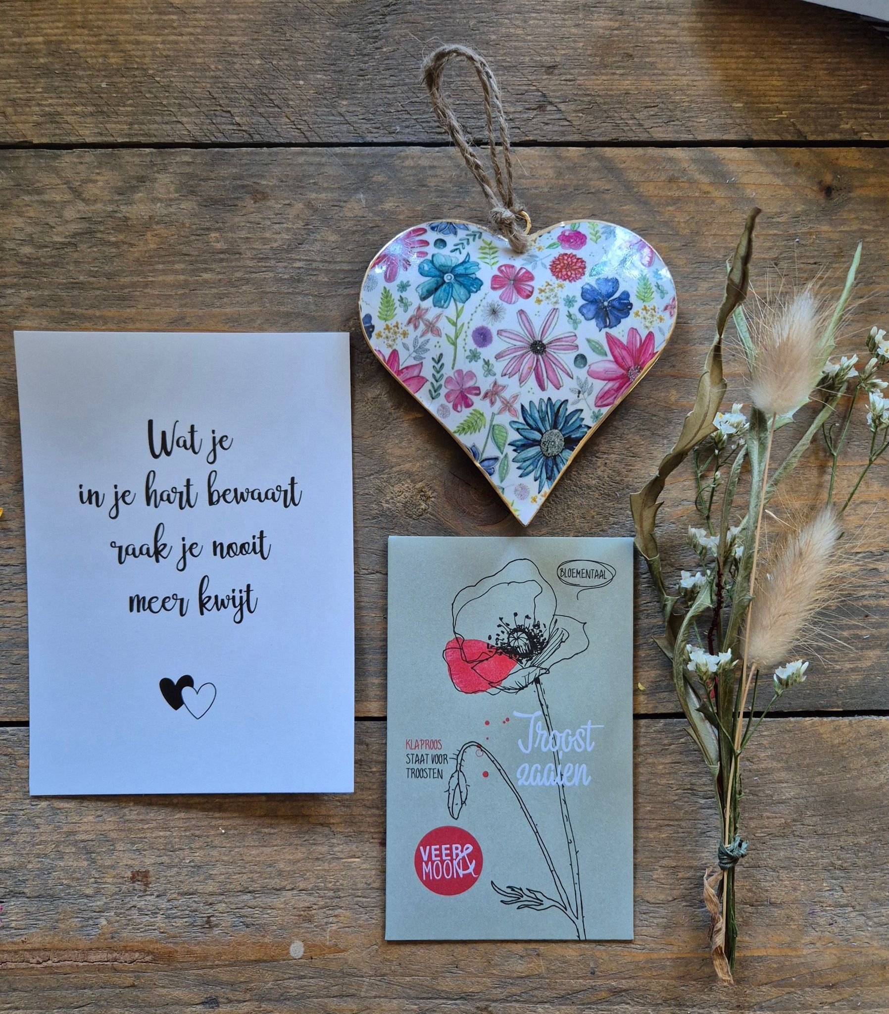 Decoratie met een houten hart, kaarten en gedroogde bloemen op een houten achtergrond. De kaarten zijn voorzien van handgeschreven tekst.