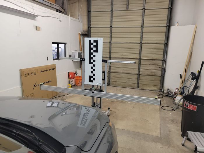 A car is parked in a garage next to a checkered board