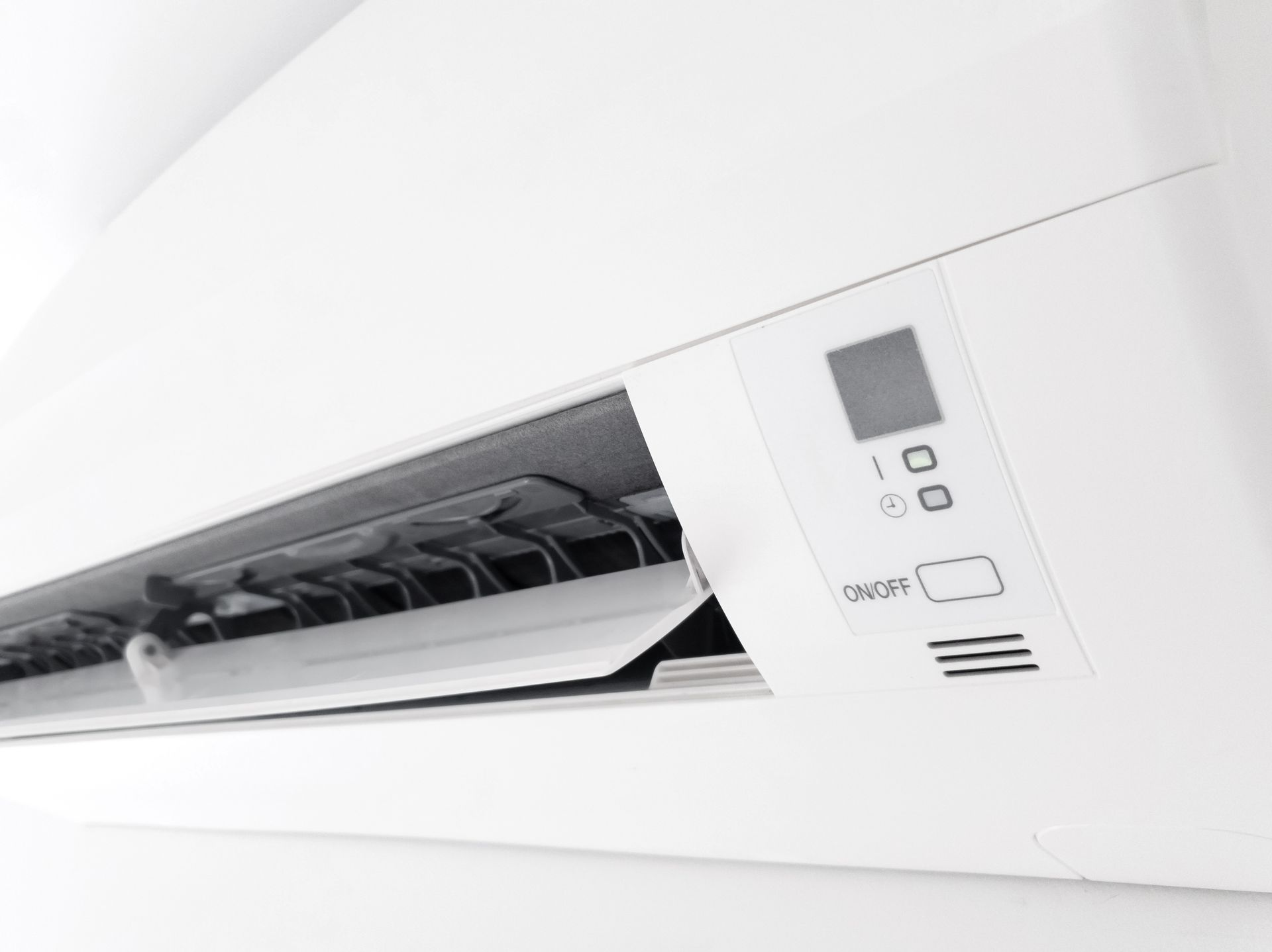 White air conditioning unit with open vents, control panel with a small screen and buttons.