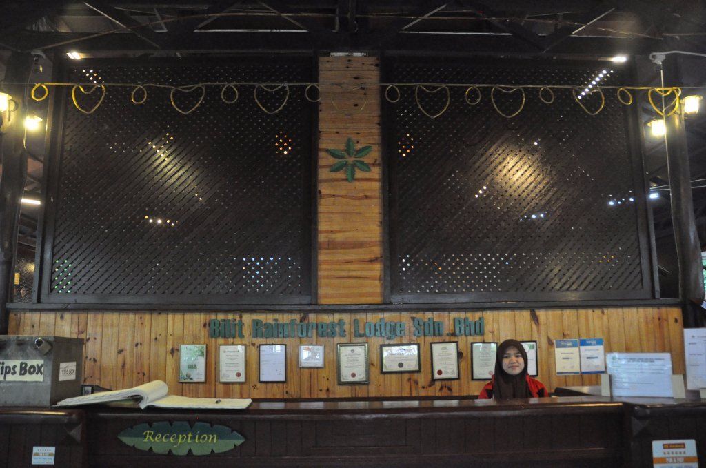 Reception desk at Wild Rainforest Lodge, with a woman smiling behind the counter.
