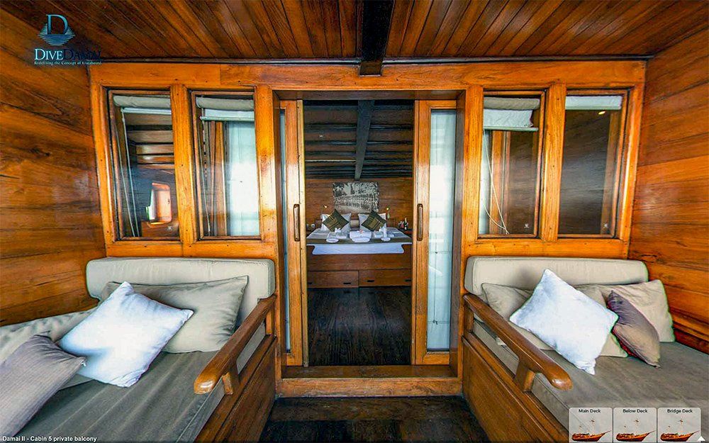 Wooden room with two cushioned benches, windows, and doorway to a dining area.