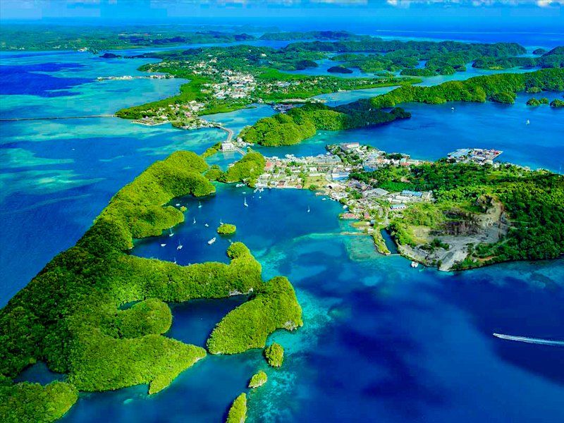 Aerial view of lush green islands surrounded by bright blue ocean water.