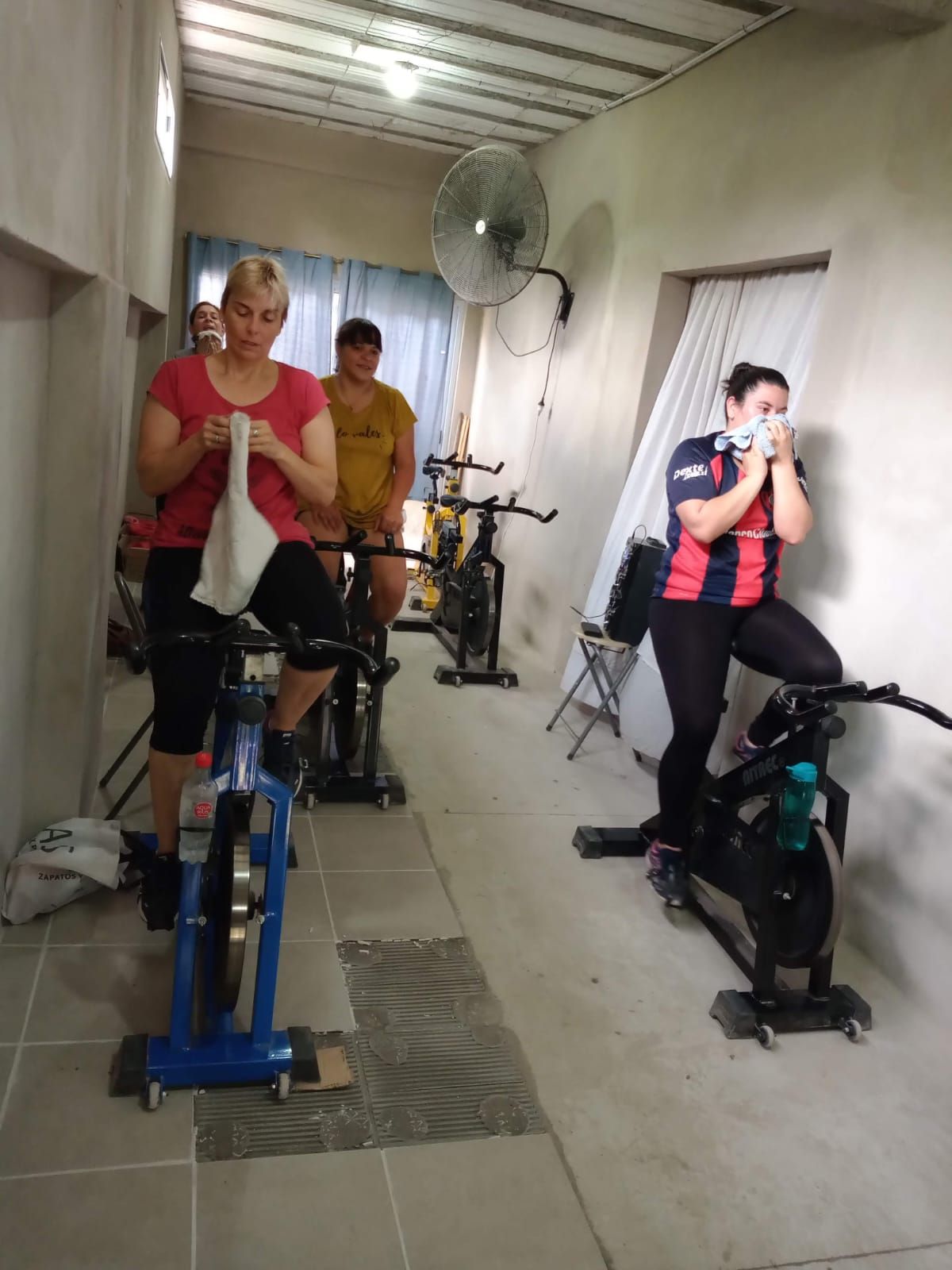 Personas en bicicleta en un espacio reducido. Una mujer en bicicleta, otras dos de pie