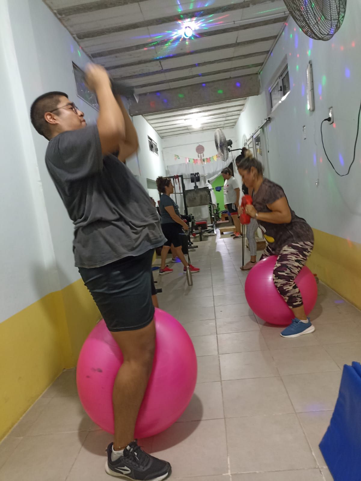 Personas ejercitándose con balones de estabilidad en un gimnasio.