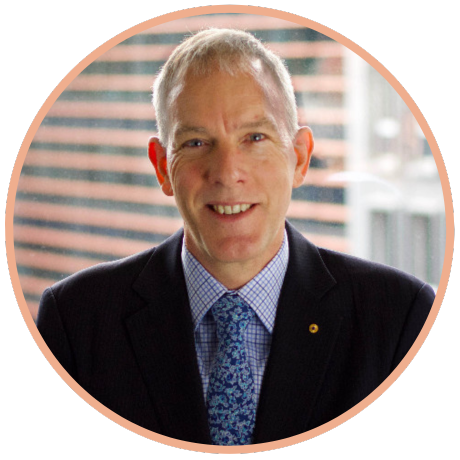A professional headshot of a smiling person wearing a dark blazer, patterned blue tie, and checkered shirt.