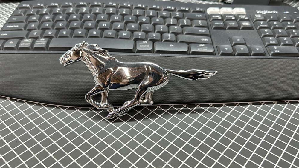 A mustang emblem is sitting on top of a keyboard