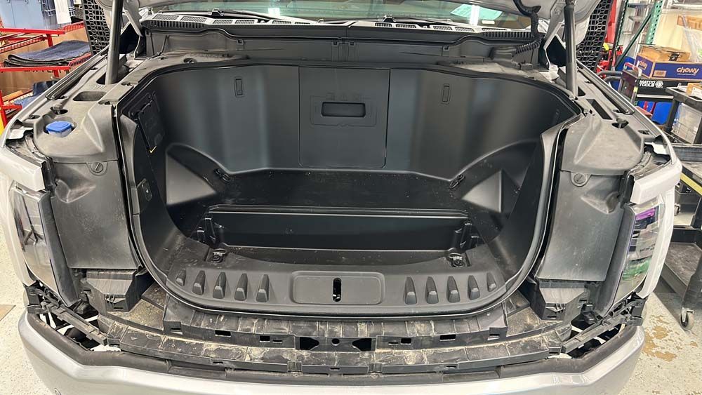 The trunk of a car with the hood open is being built.
