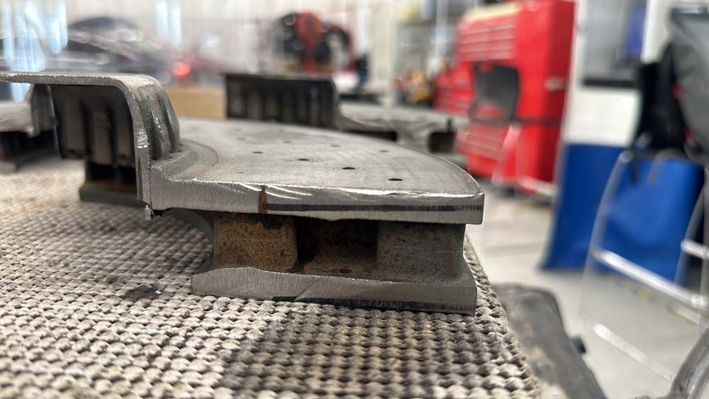 A piece of metal is sitting on top of a table in a garage.