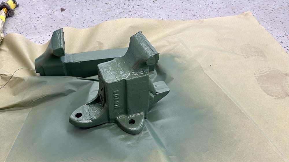 A vise is sitting on a piece of paper on a table.