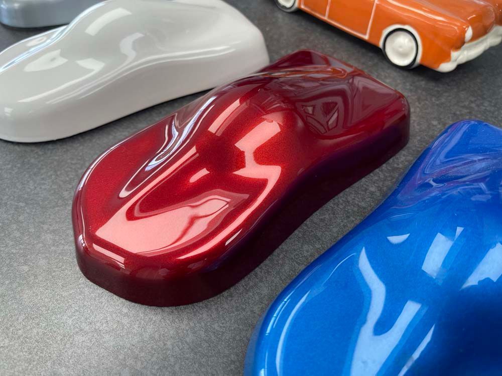 Three different colored cars are sitting next to each other on a table.