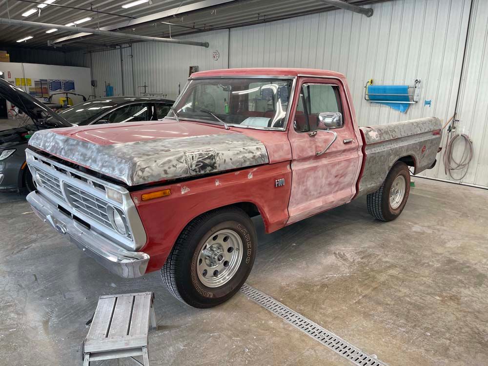 A red pickup truck is sitting in a garage.