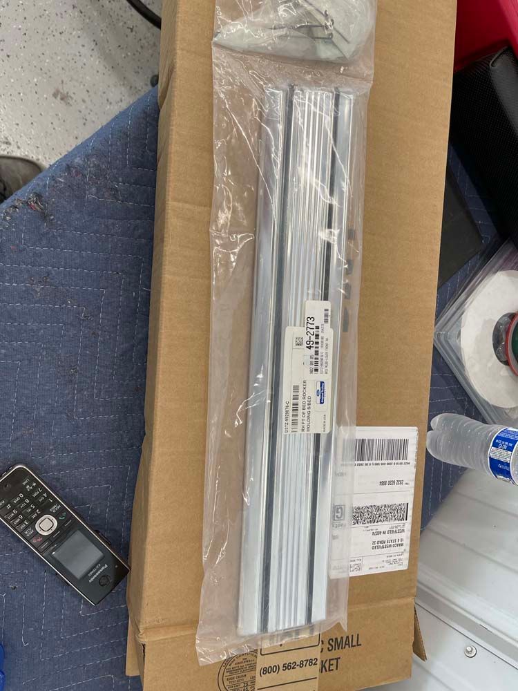 A cardboard box filled with a bunch of pieces of metal