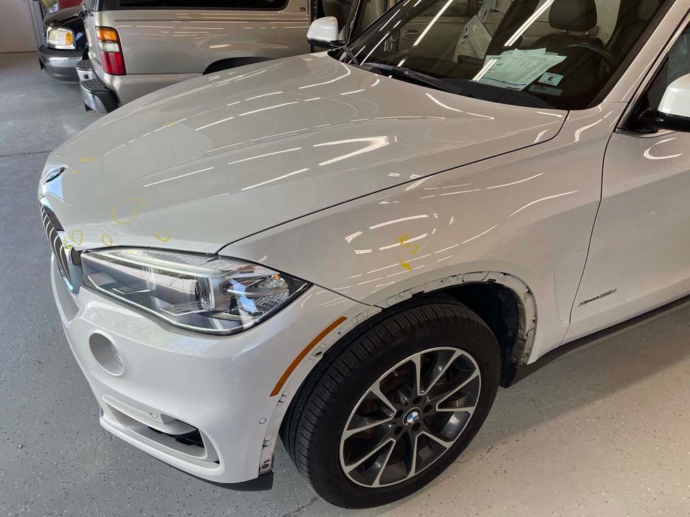 A white bmw x5 is parked in a garage.