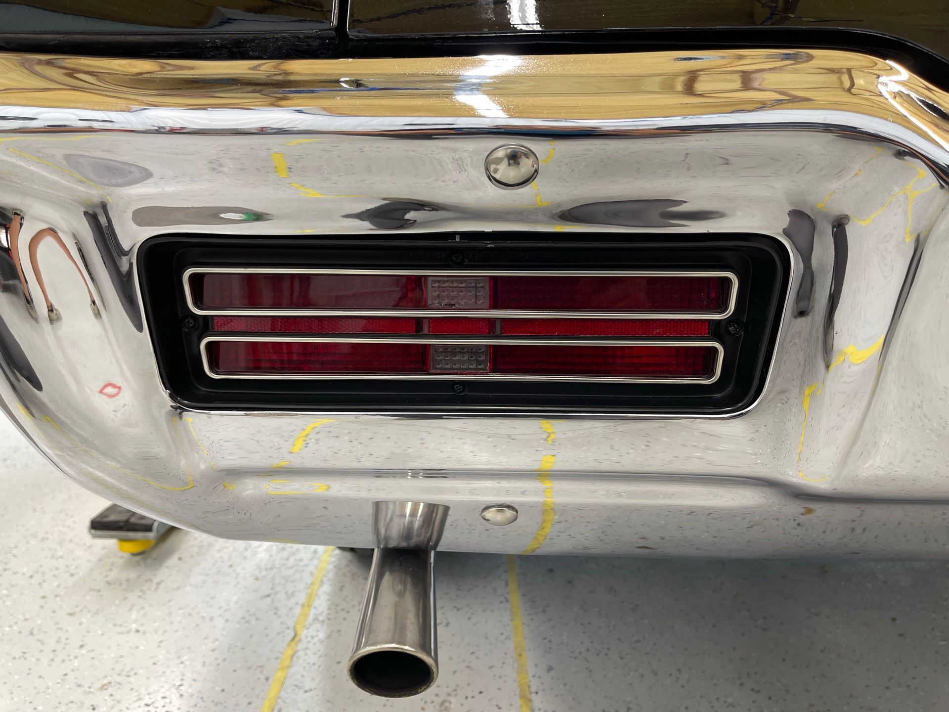 A close up of a car 's tail light and exhaust pipe.