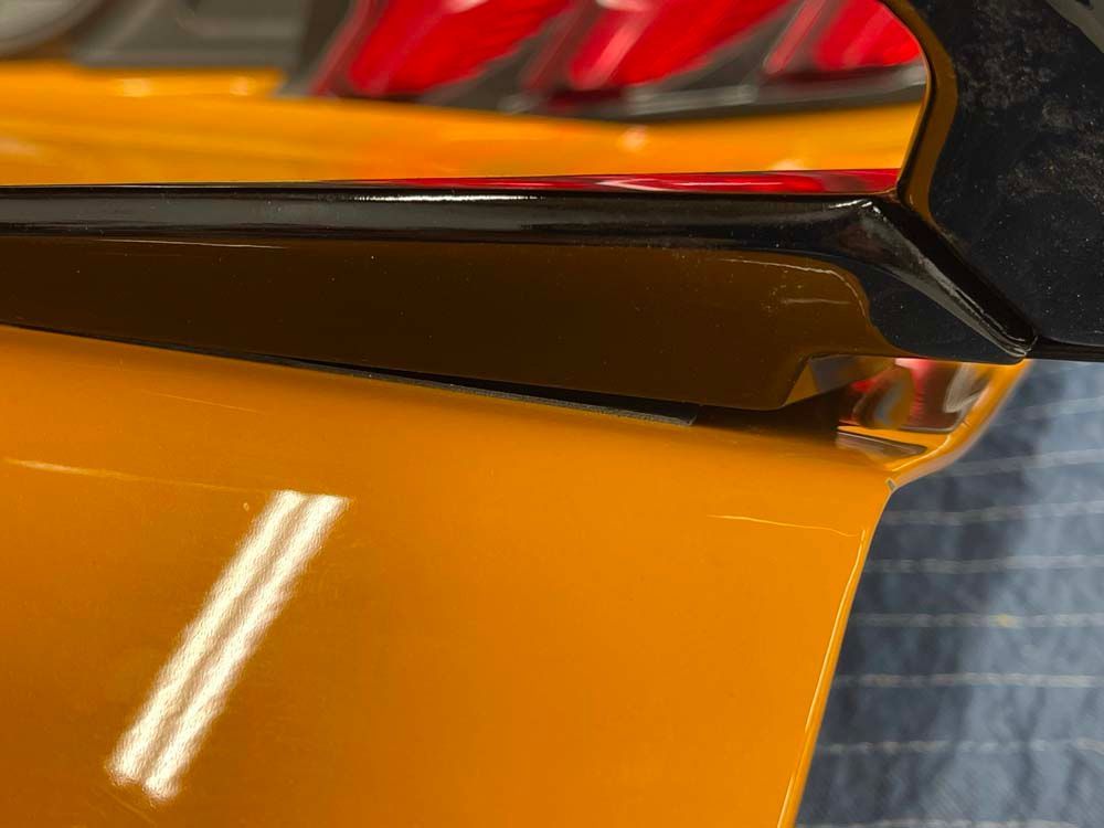 A close up of a yellow car with red tail lights.