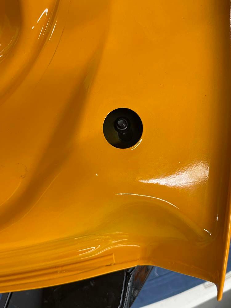 A close up of a yellow object with a hole in it.