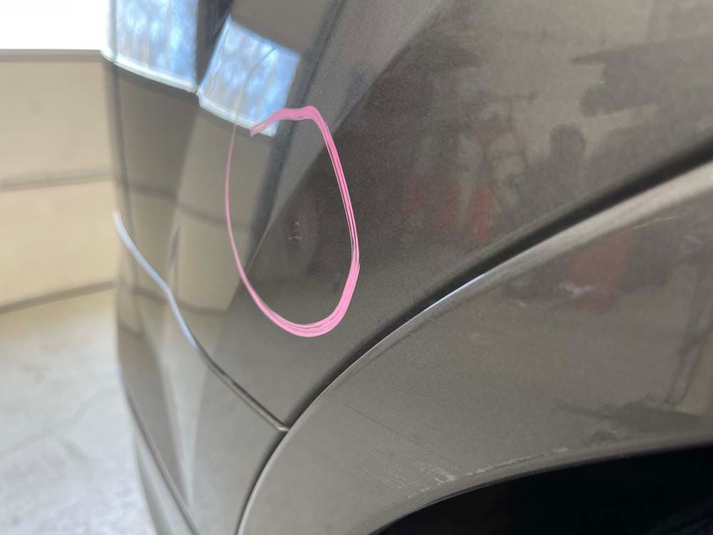 A close up of a car with a pink circle drawn on it.