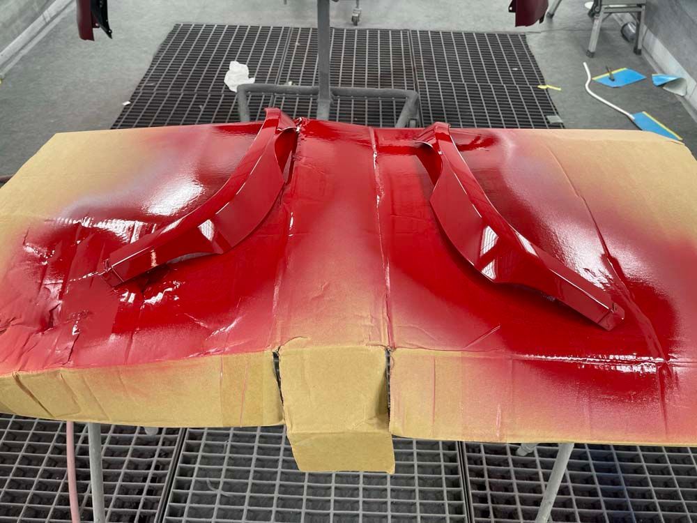 A piece of cardboard is covered in red paint