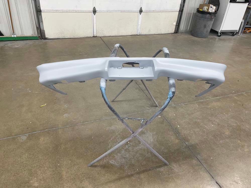 A bumper is sitting on a stand in a garage.