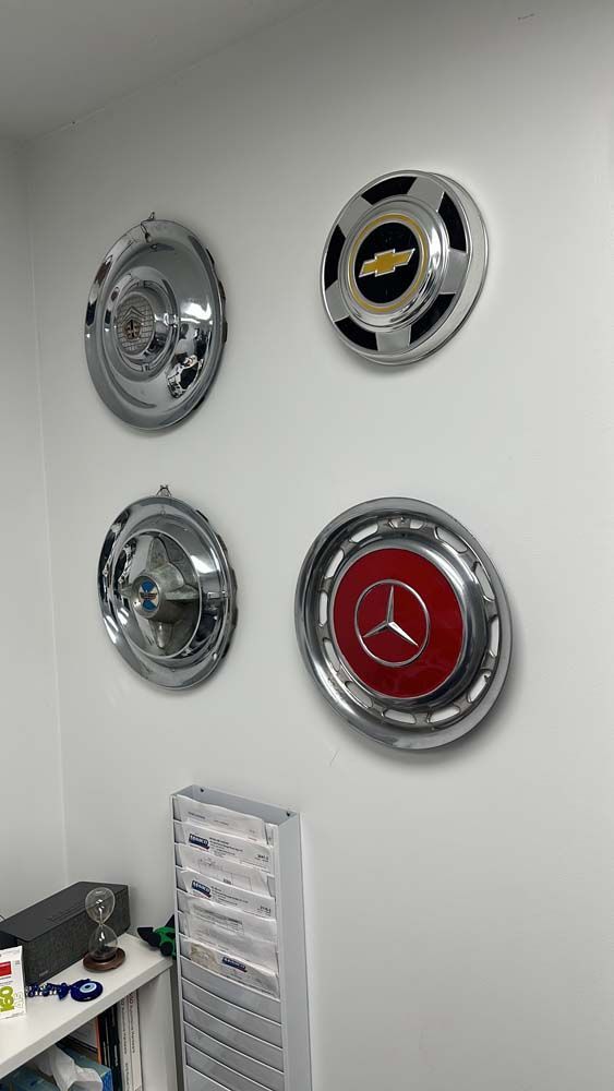 Four wheel covers are hanging on a wall in a room.