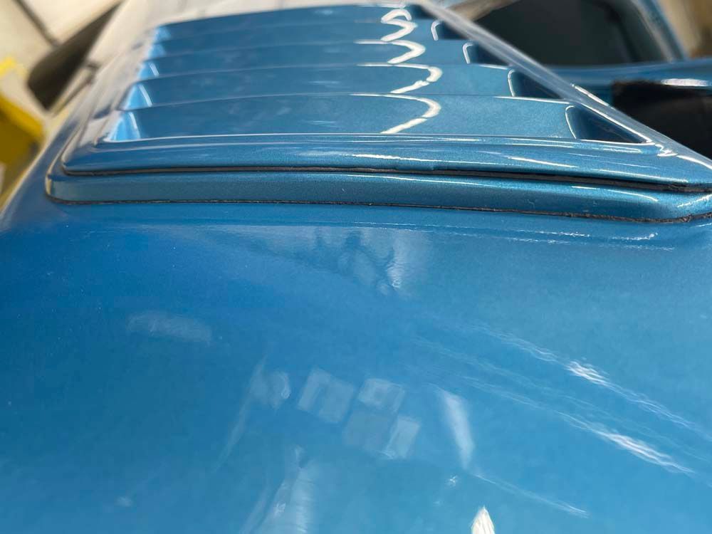 A close up of the hood of a blue car