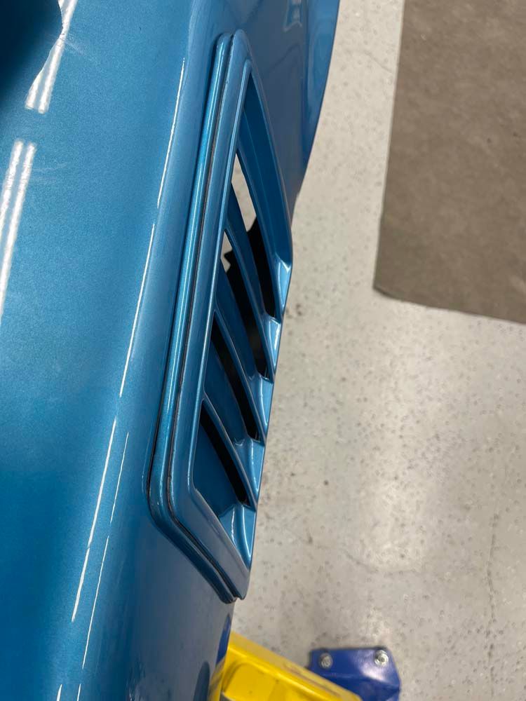 A blue car with a yellow box on the floor