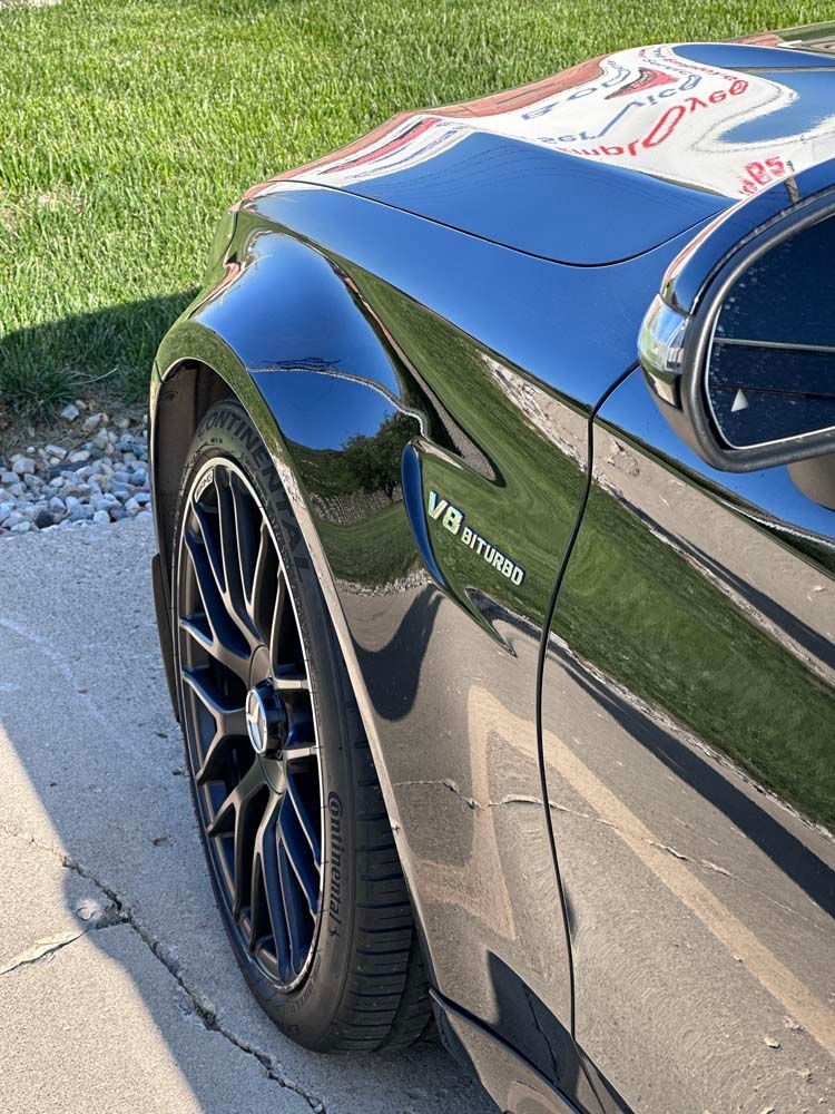 A black sports car is parked on the side of the road.
