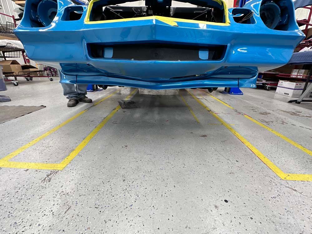 A blue car is sitting on a lift in a garage