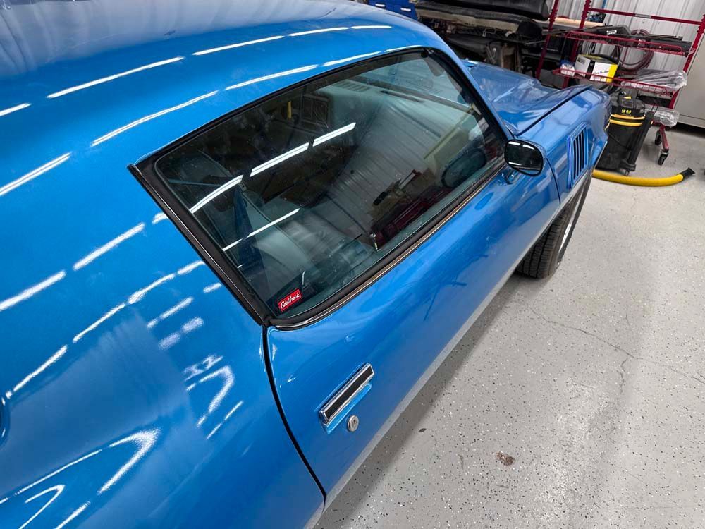 A blue car is parked in a garage.
