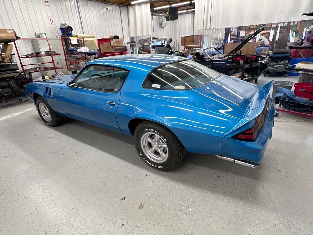 A blue car is parked in a garage.