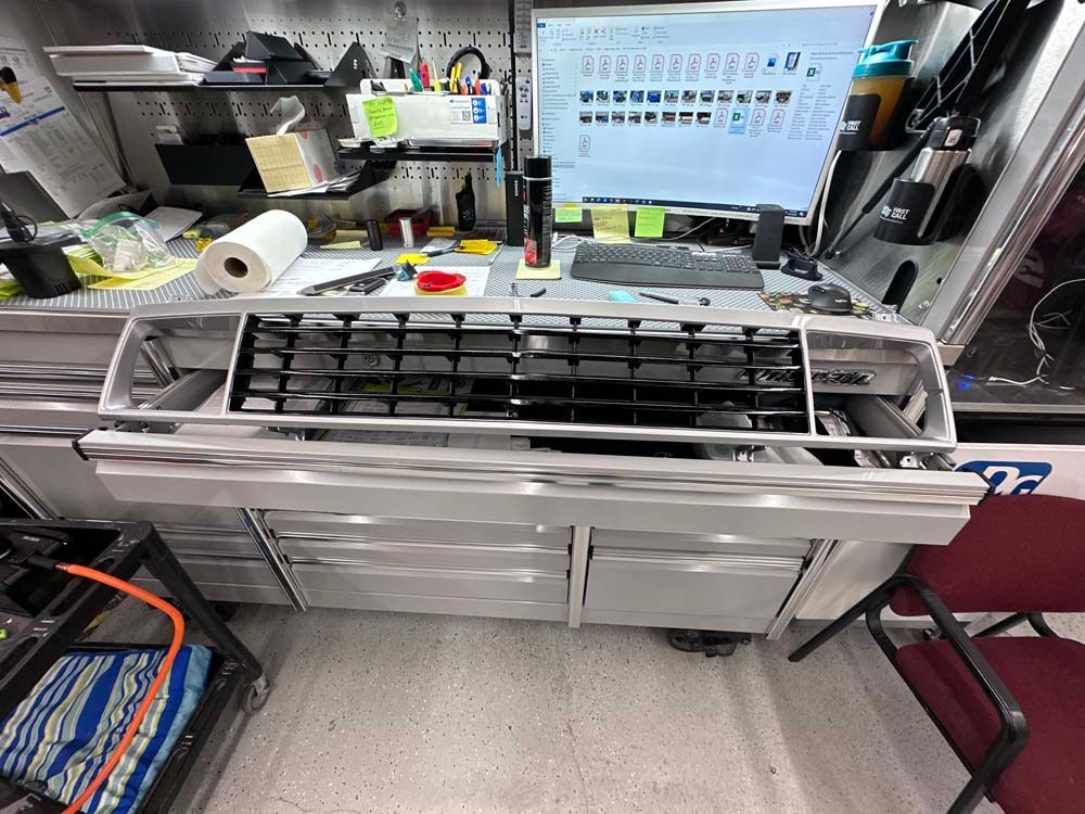 A computer monitor is sitting on top of a desk in a garage.