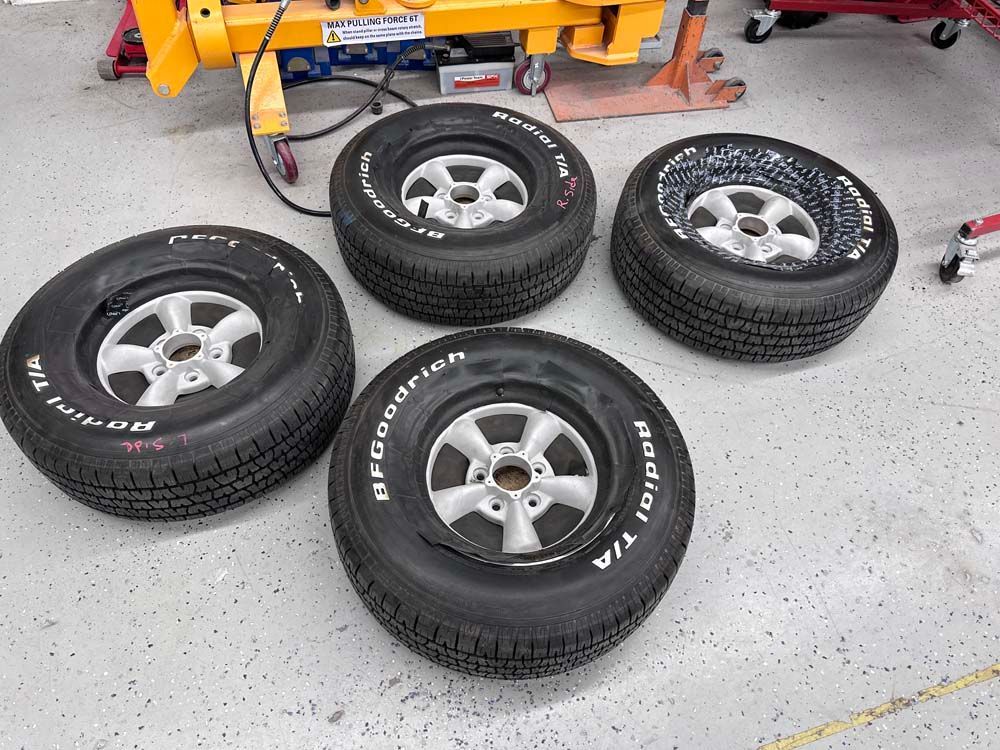 Four bfgoodrich tires are sitting on a concrete floor