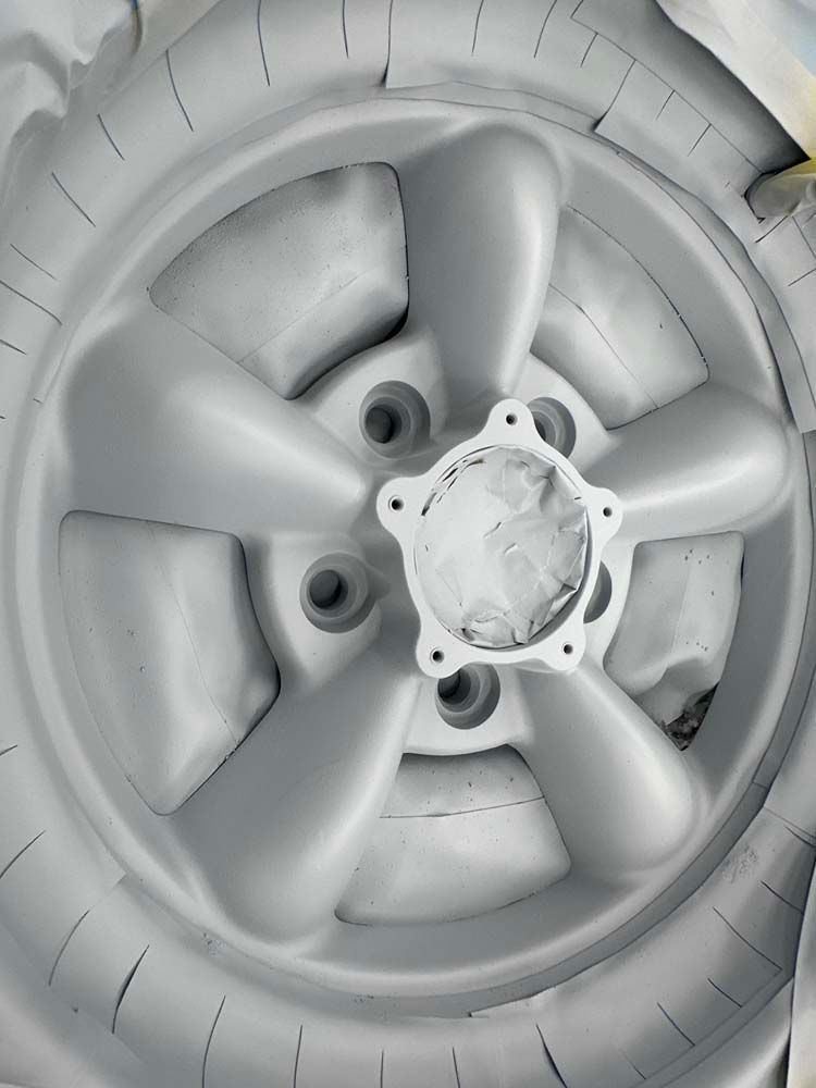A close up of a white wheel with holes in it