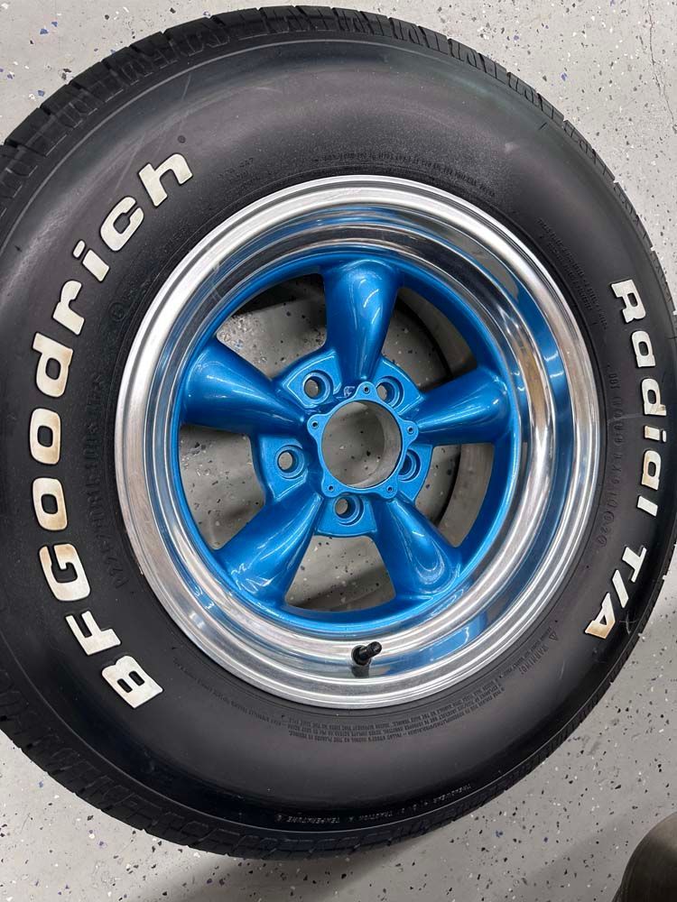 A close up of a bfgoodrich tire on a blue wheel