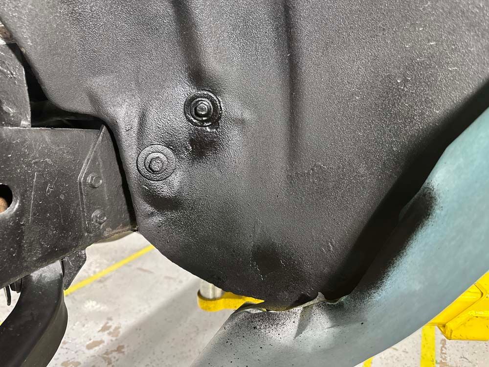 A close up of a black object with a screw in it.