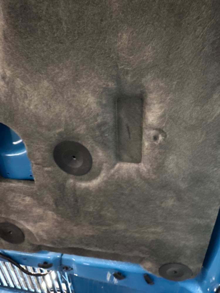 A close up of the hood of a blue car.