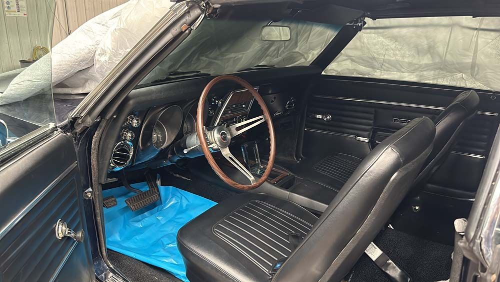 The inside of a black car with a steering wheel