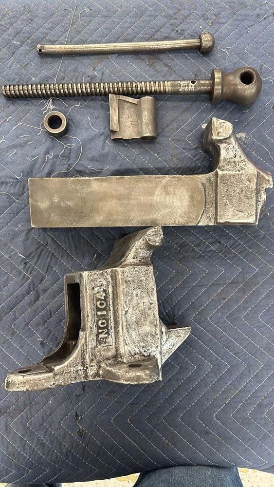 A vise is sitting on top of a blue blanket on a table.