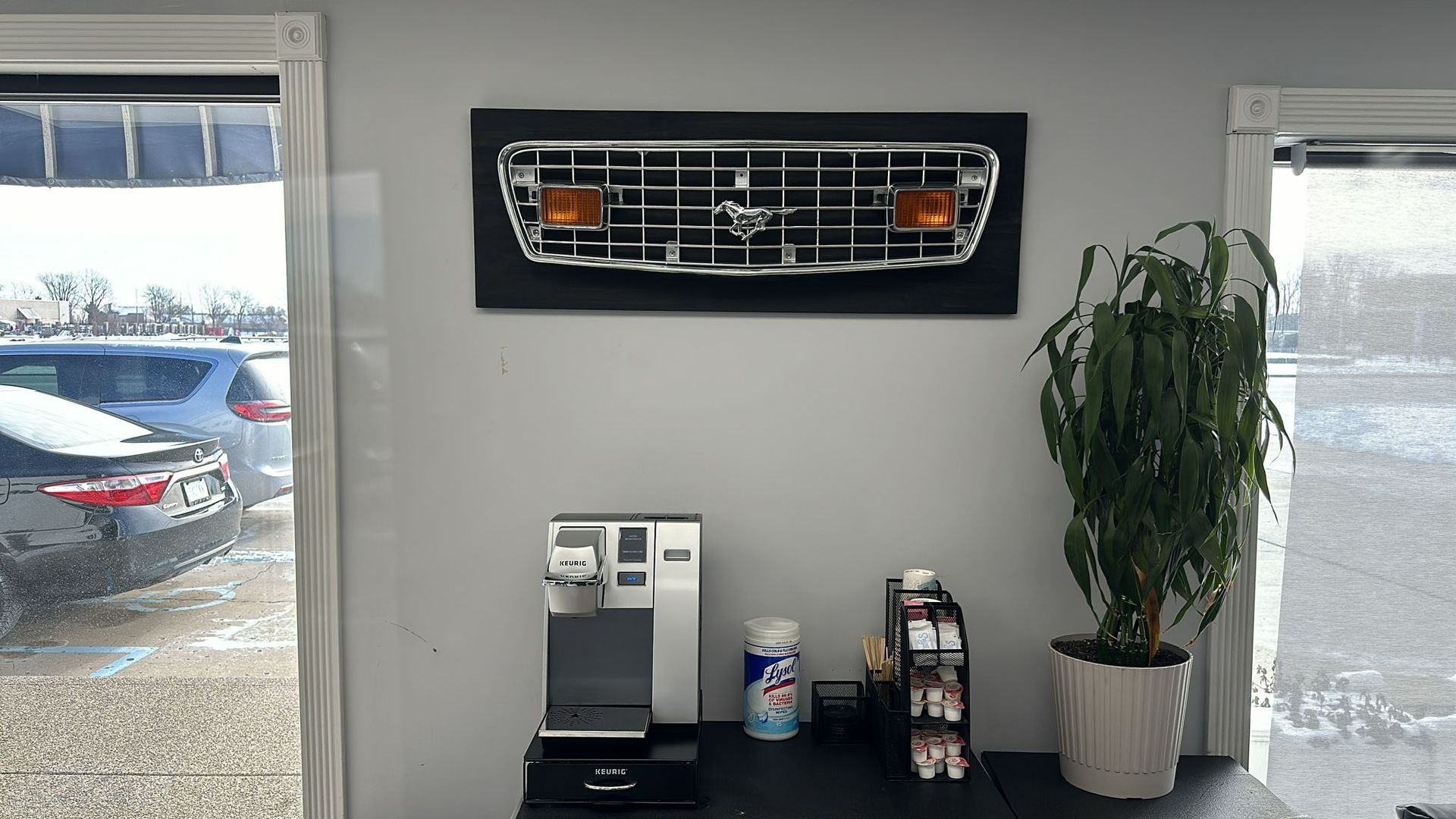 A picture of a ford grille is hanging on a wall in a room.