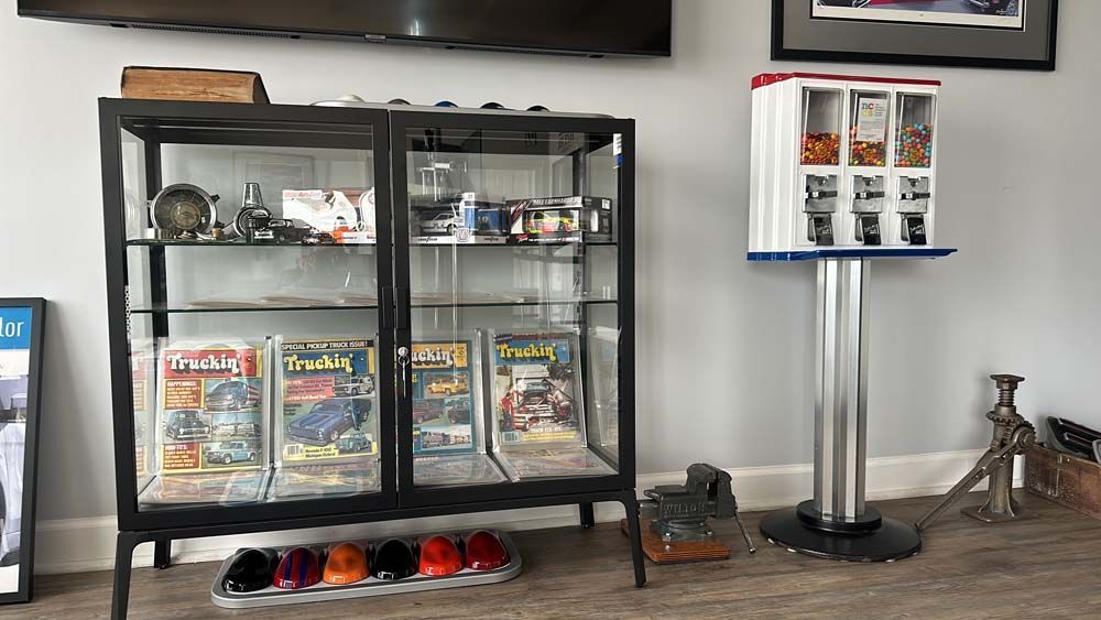 A living room with a glass display case and a gumball machine.