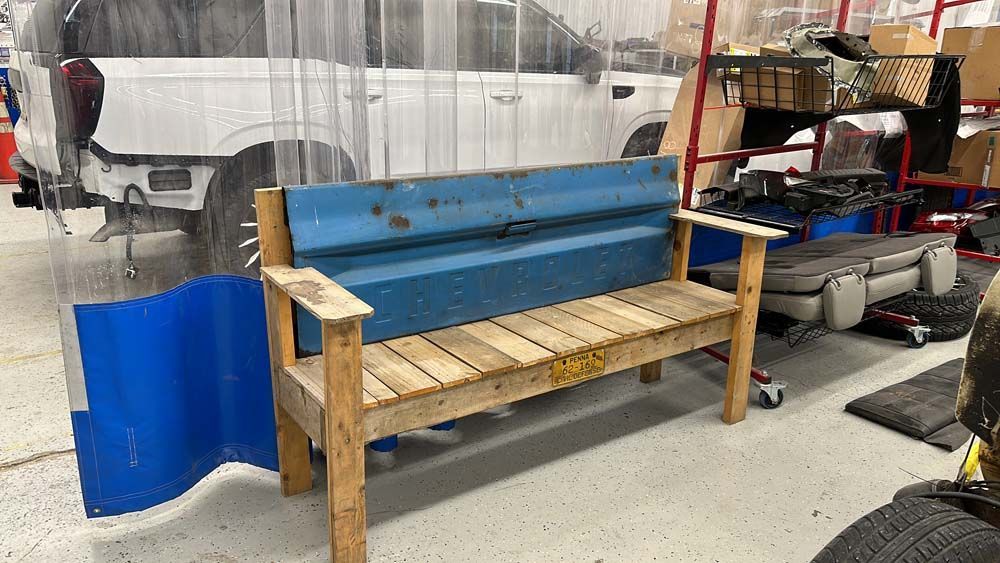 A wooden bench made out of a truck bed in a garage.