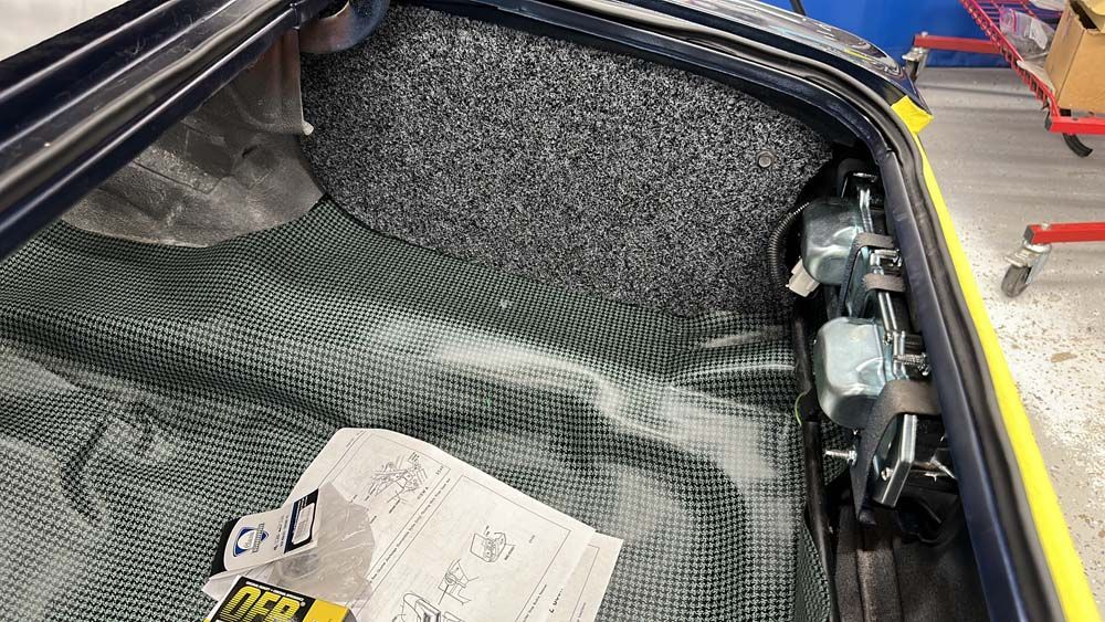 The trunk of a car is being worked on.