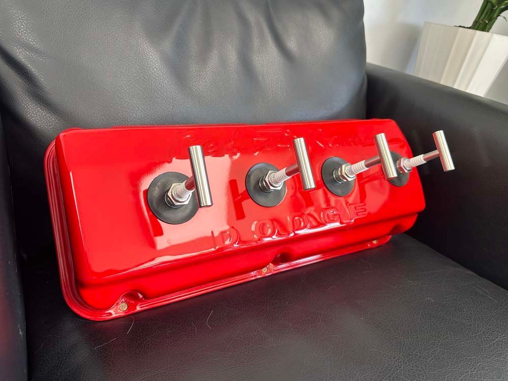 A red valve cover is sitting on a black leather chair