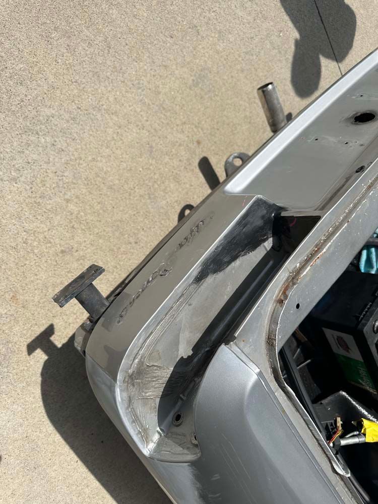 A silver car is sitting on a concrete surface.