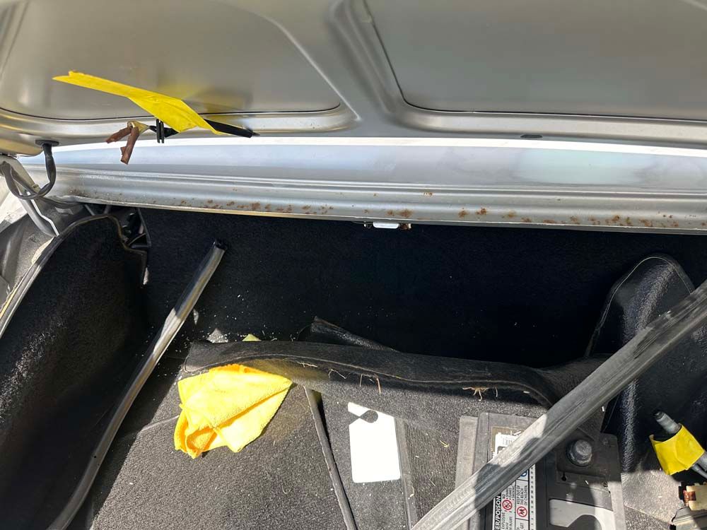 The trunk of a car with a yellow tag on it.