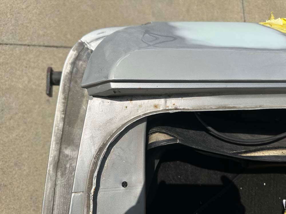 A close up of a roof of a car on a sidewalk.