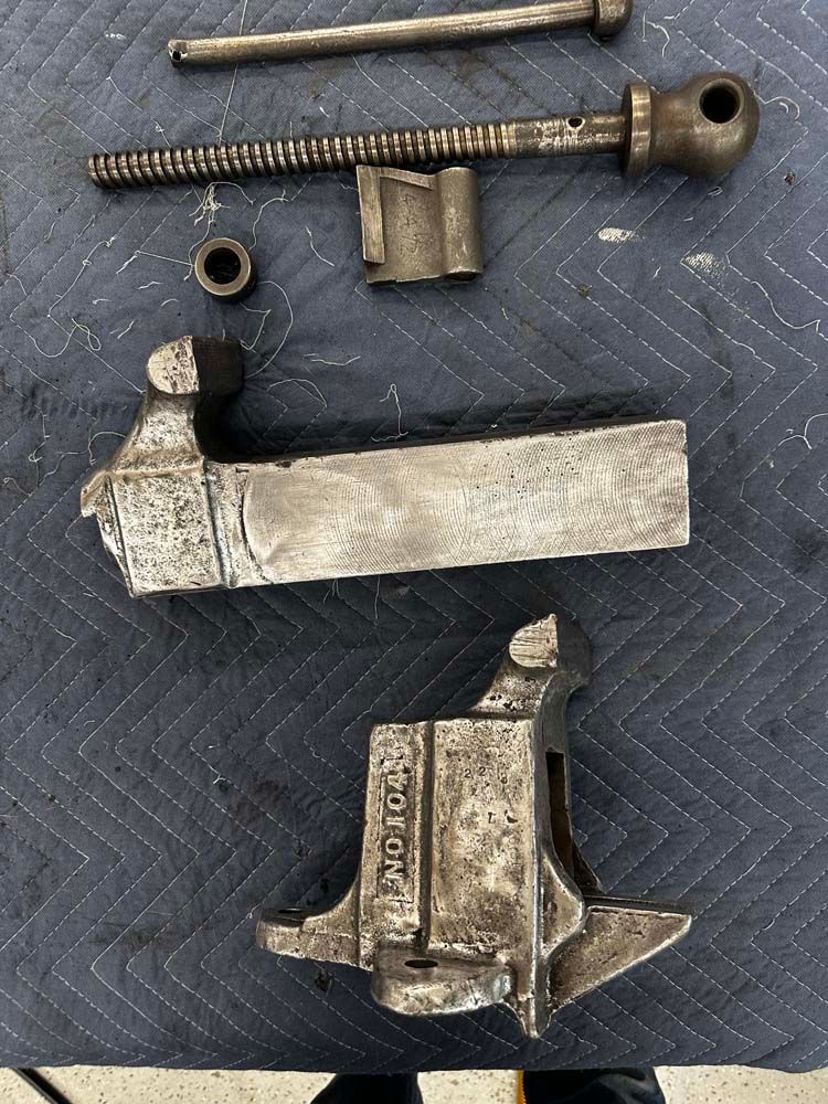 A piece of metal is sitting on top of a blue blanket on a table.