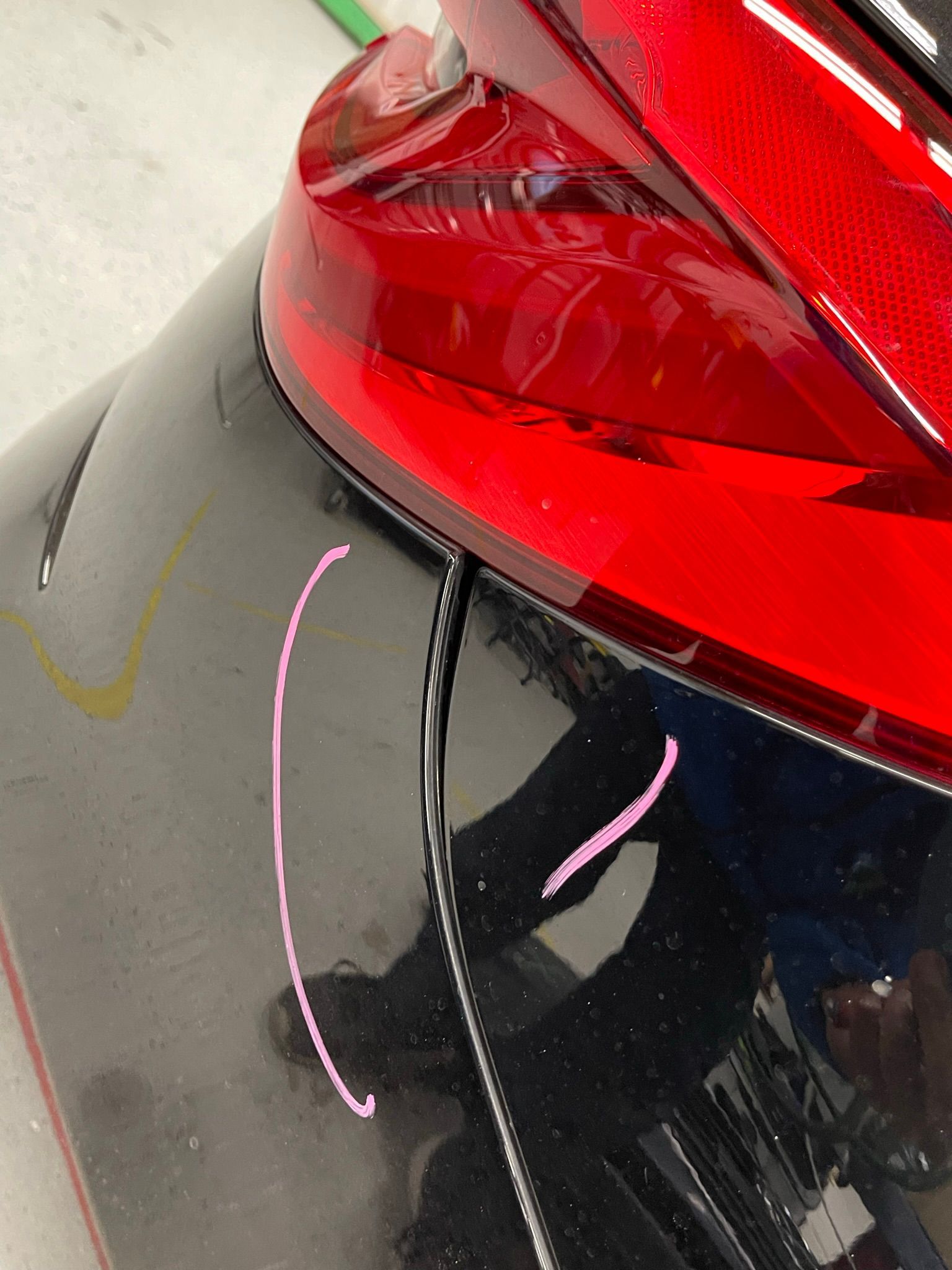 A close up of a black car with a red tail light