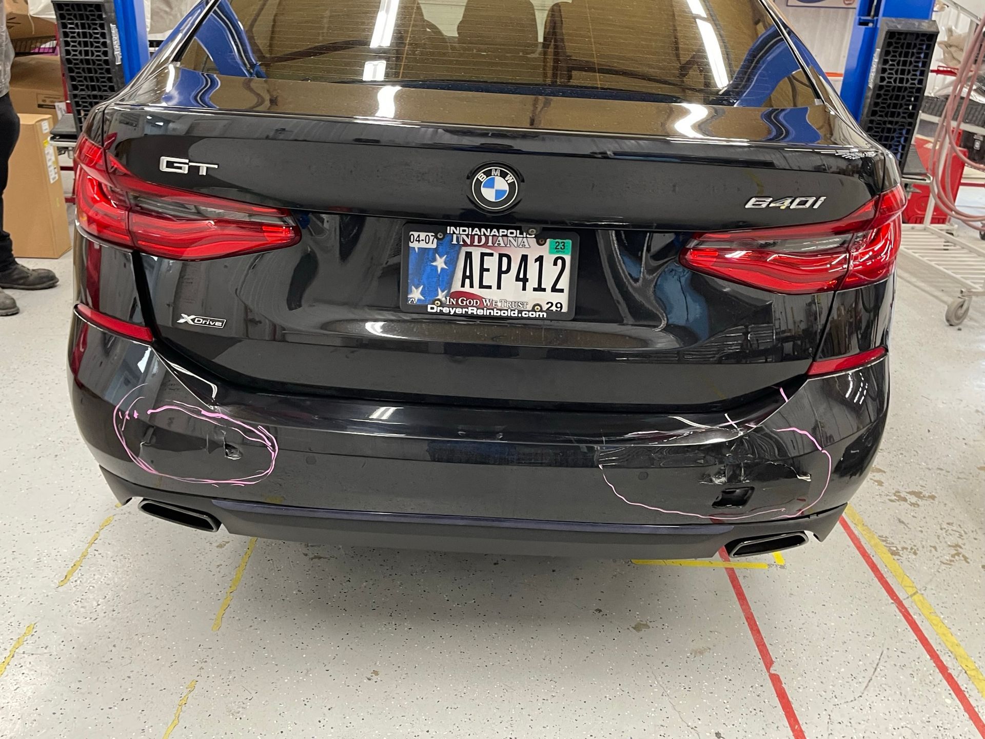 A black bmw with a license plate that says aep412