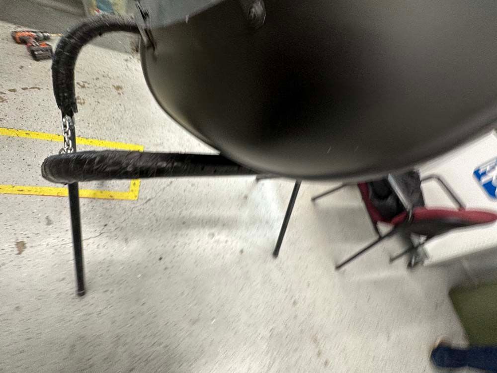 A black pot is sitting on a table next to a chair.